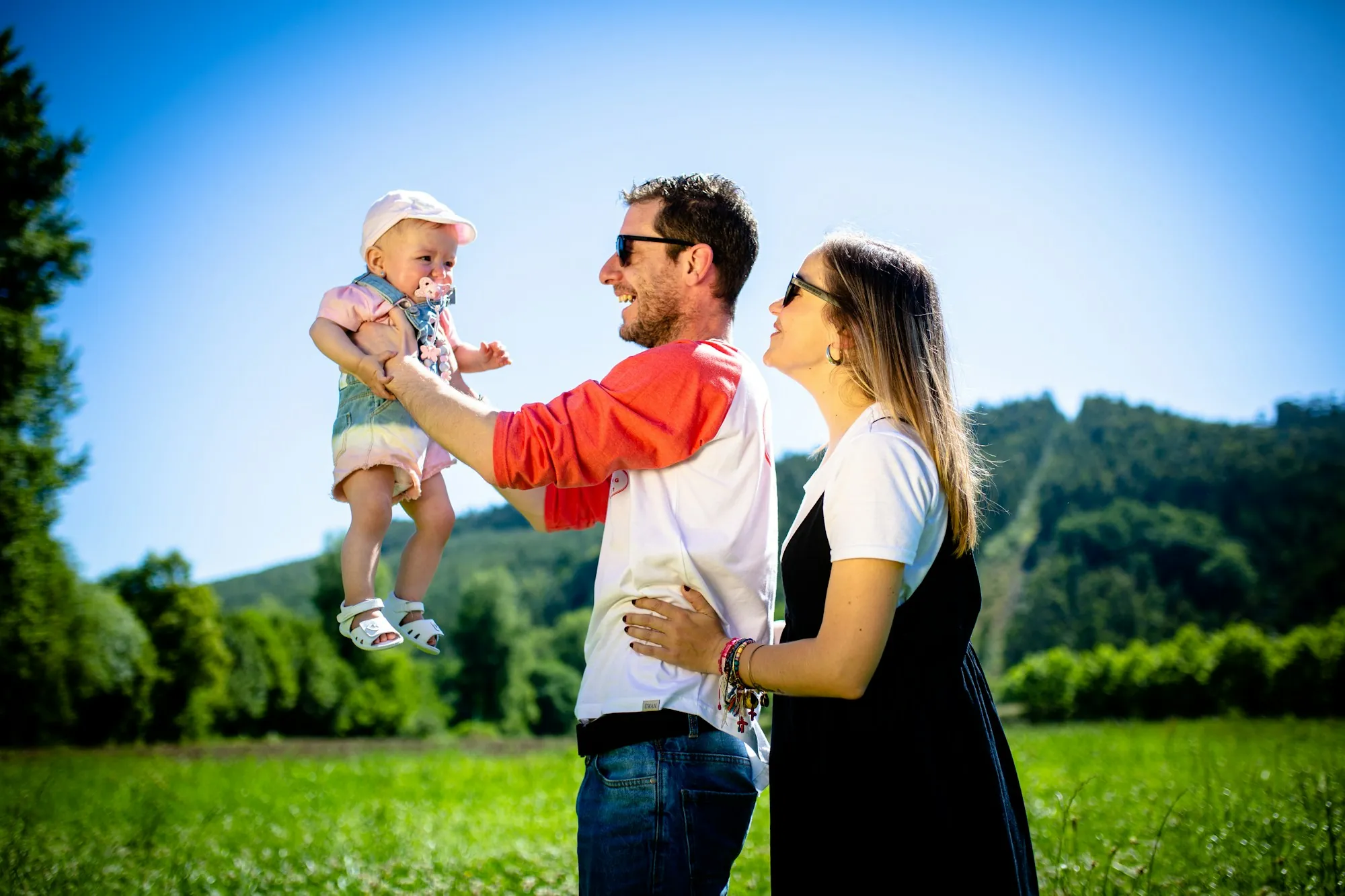 Father lifting a laughing toddler in a park, the family a life insurance claim is paid to protect in Deer Park